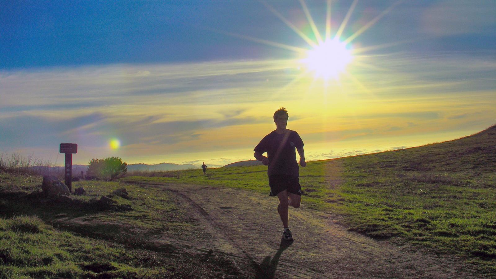 a runner on a trail in the late afternoon