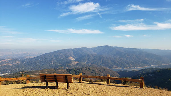 a bench overlooking a reservoir and hills