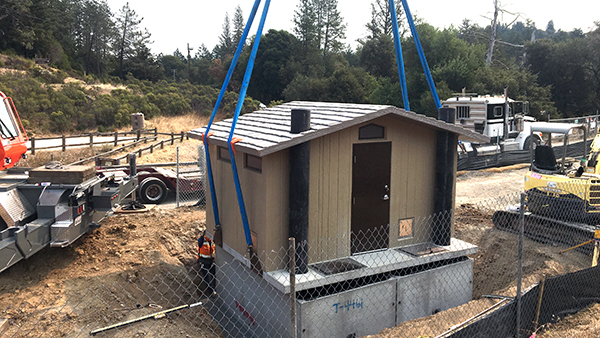 a crane moving a modular restroom into place