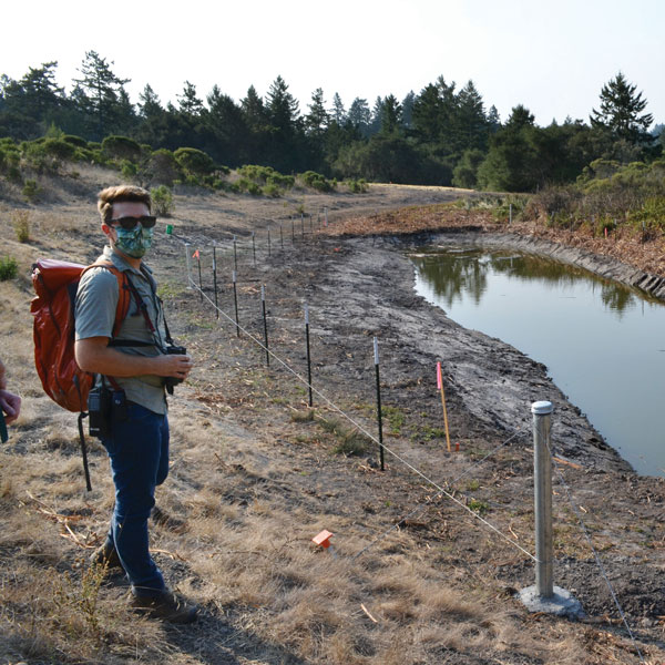 man standing next to pond