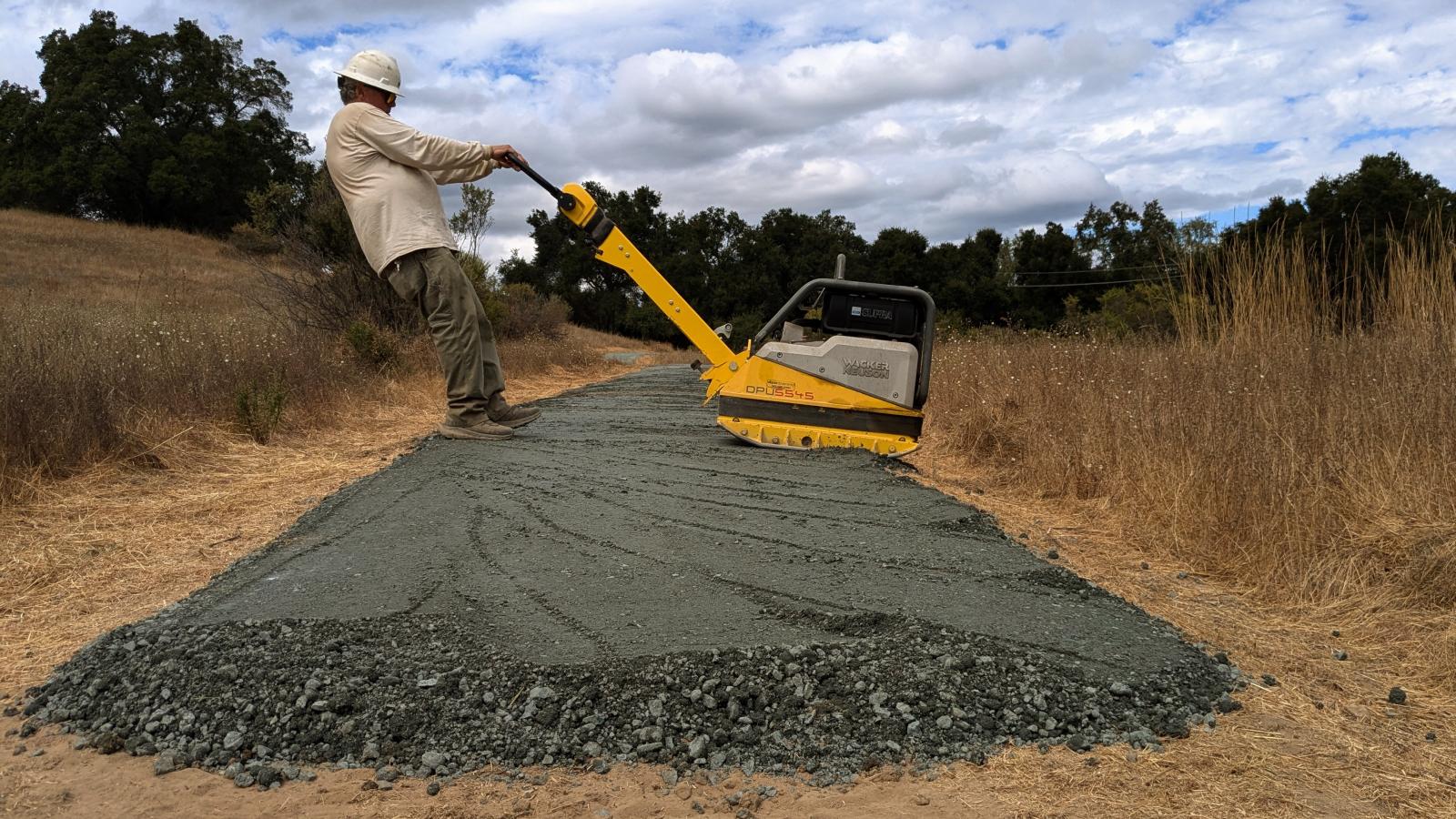 Man uses a piece of handheld machinery to build a new trail