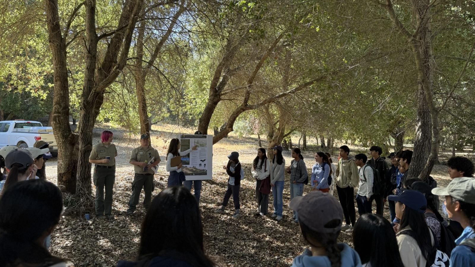 Group of people gathered outside listening to presentation by Midpen staff