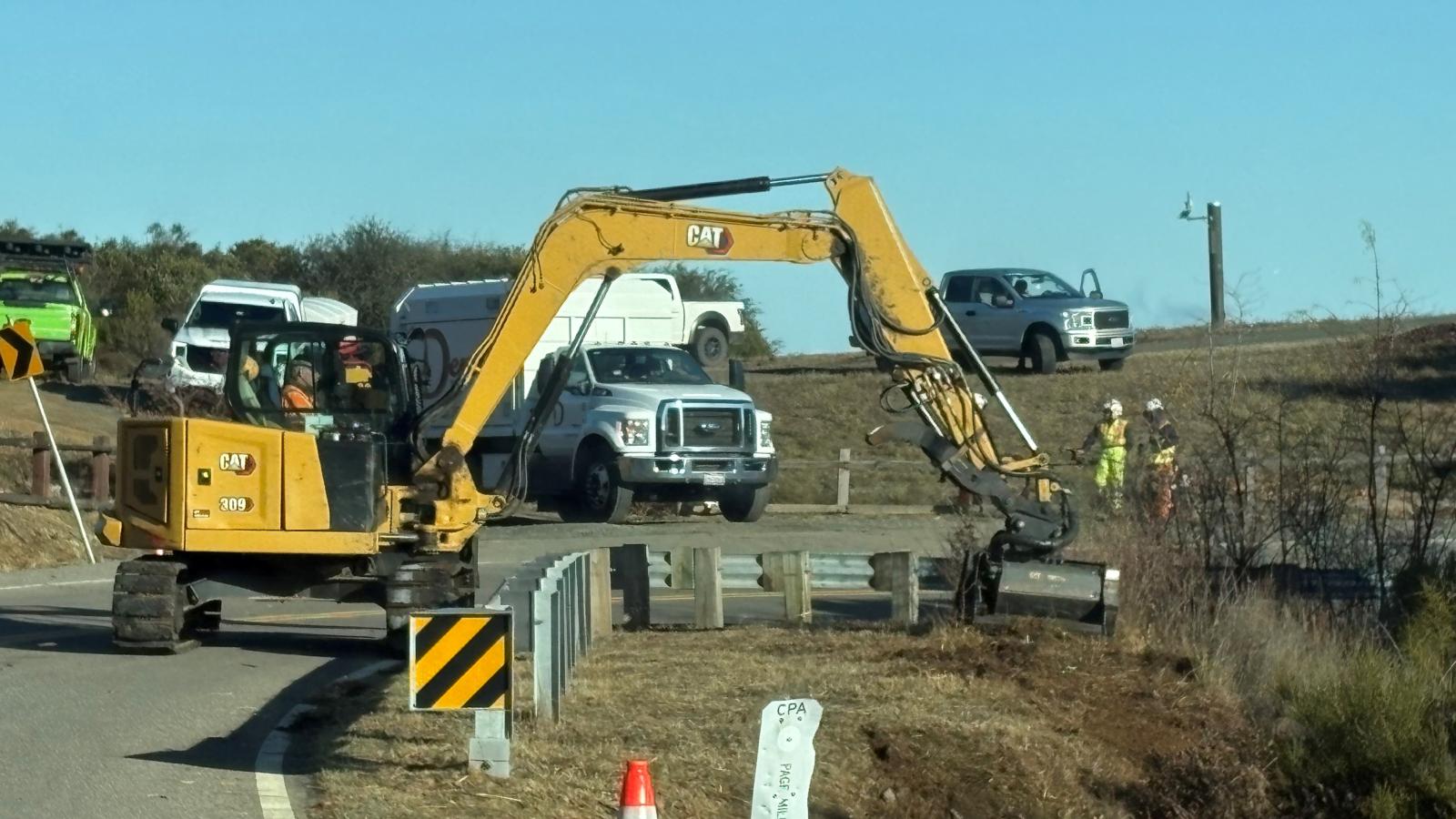 Crew uses an excavator to clear vegetation along Page Mill Road to maintain an emergency escape route in case of wildland fire