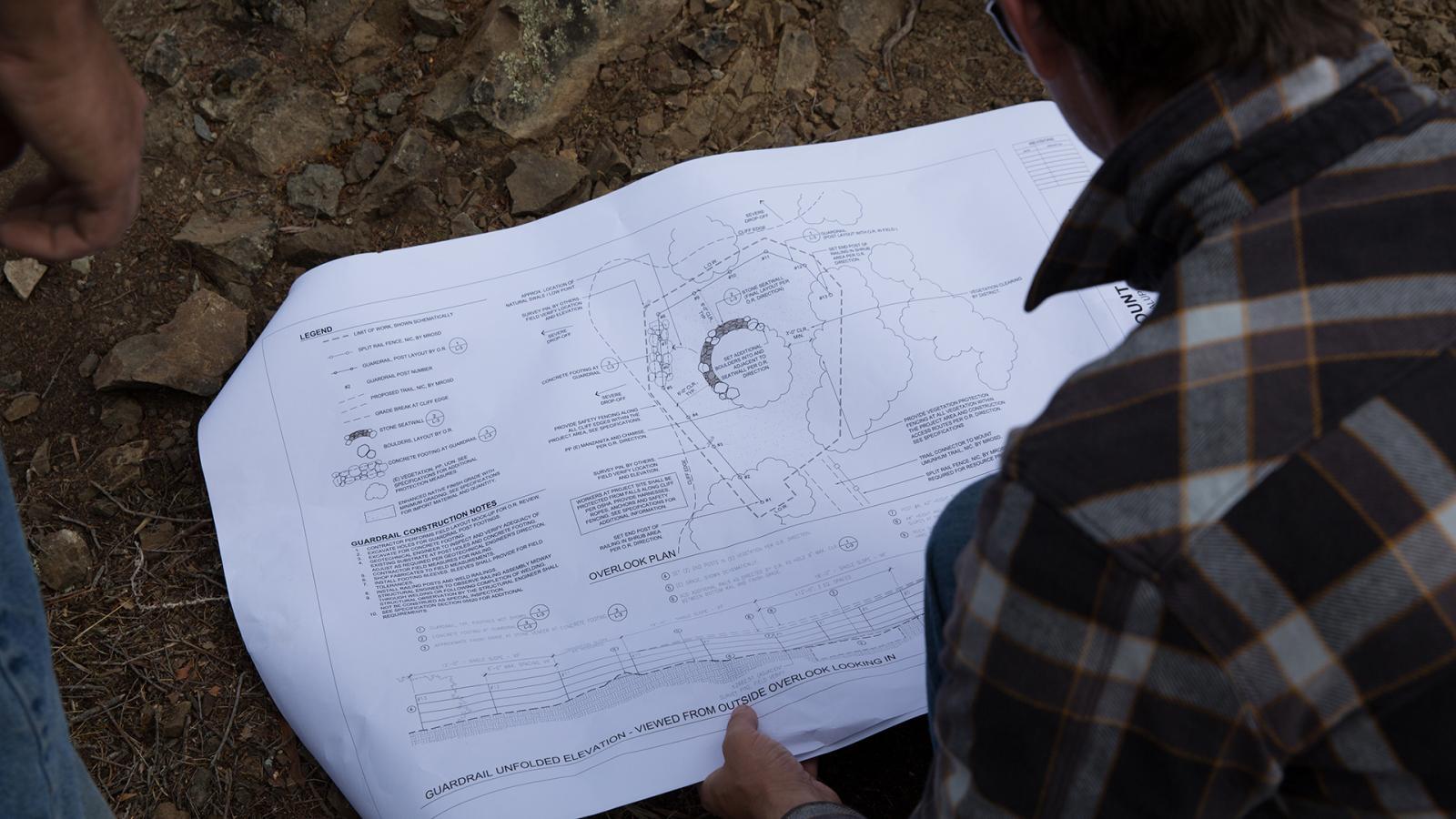a person looking at a construction drawing