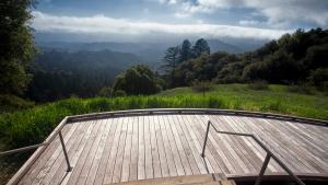view of the hills and ocean from a wooden deck