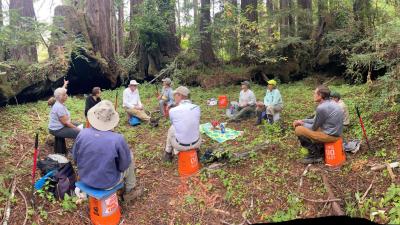 Volunteers sitting around buckets and tools at La Honda Creek Volunteers sitting around buckets and tools at La Honda Creek