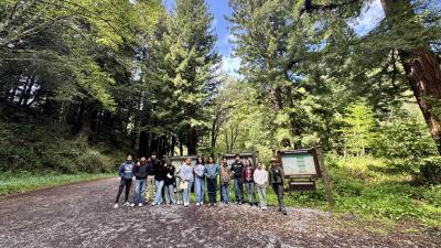 Group of people gathered at trail sign during community event