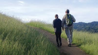 a man and woman walking on a trail