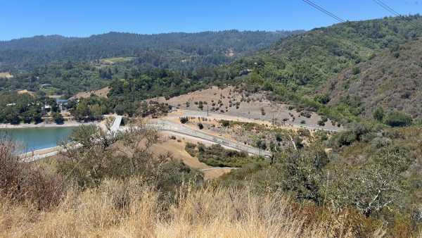 Hilltop vista looking at Highway 17 with the Lexington Reservoir to the left cars driving on the road
