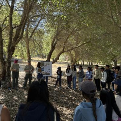 Group of people gathered outside listening to presentation by Midpen staff