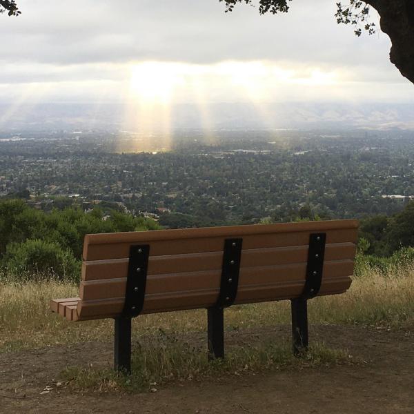 a bench on a hilltop overlooking the valley below